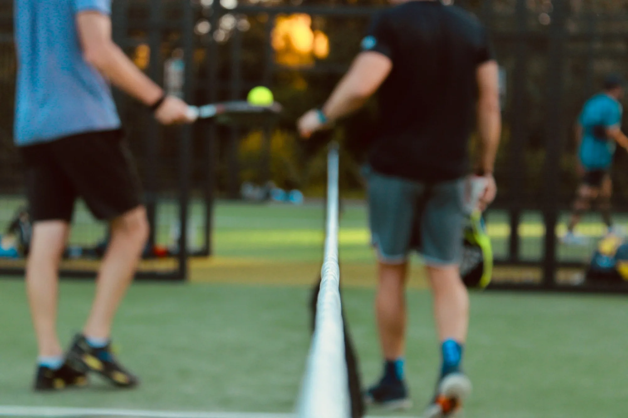 Deux joueurs de chaque côté du filet sur un terrain de padel