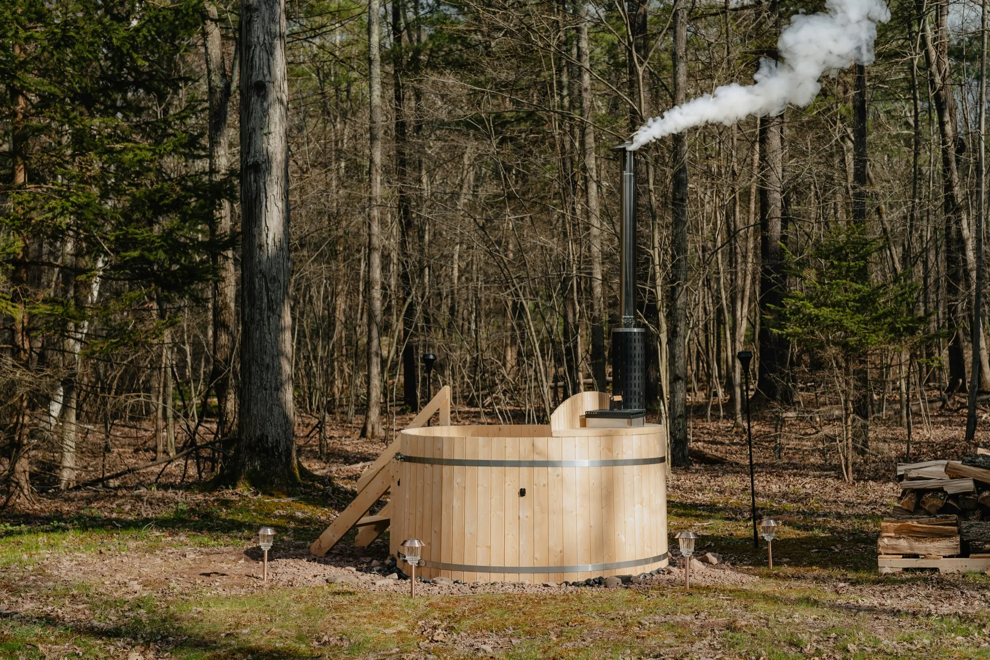 Bain nordique en bois fumant en lisière de forêt