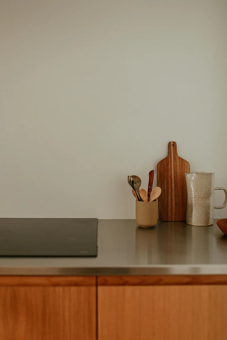 Plan de travail en inox et ustensiles en bois dans une cuisine