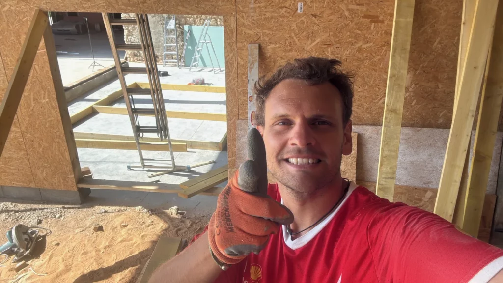 Un des fondateurs sur le chantier de la Villa Perchée, devant l'ossature bois de la future salle