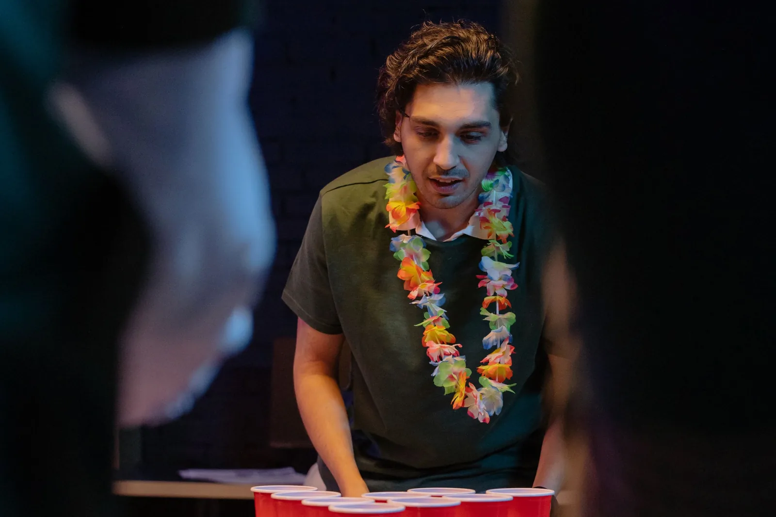 Jeune homme concentré sur une partie de beer pong lors d'une soirée d'EVG