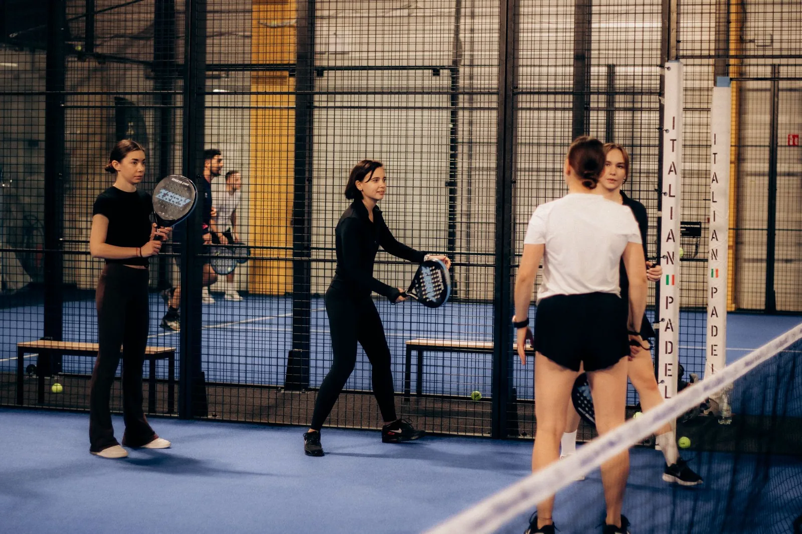 Partie de padel en double sur un terrain vitré