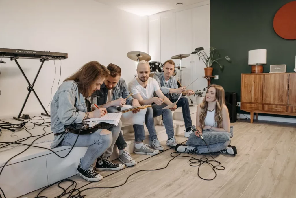 Groupe de musiciens en répétition dans une maison, résidence musicale