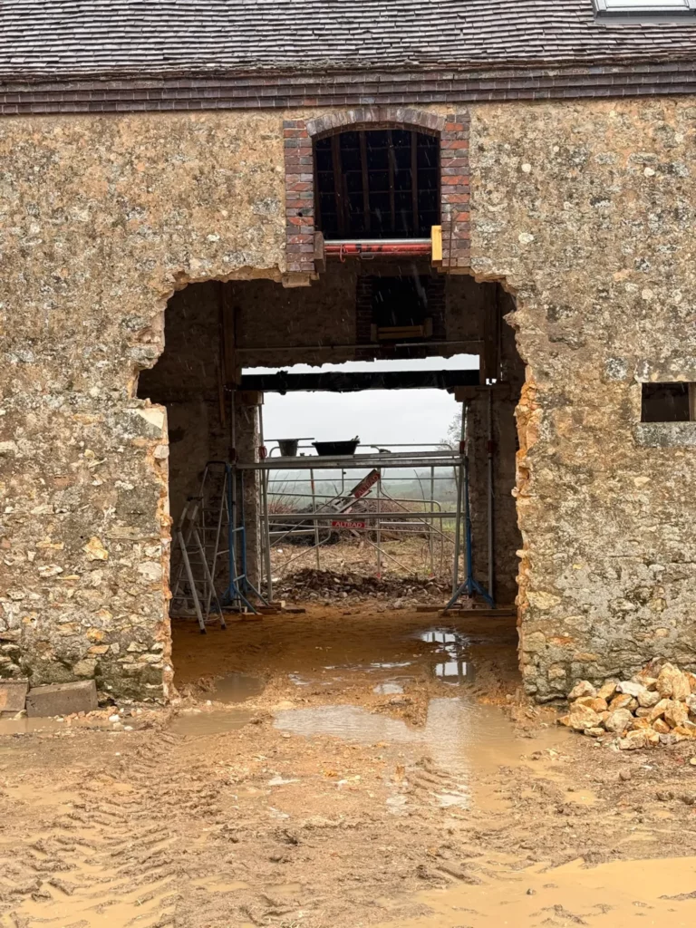 Façade en pierre de l'espace de réception pendant l'ouverture d'une grande baie
